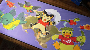 A deskmat featuring characters from Tee K.O. jumping up from a volcano island